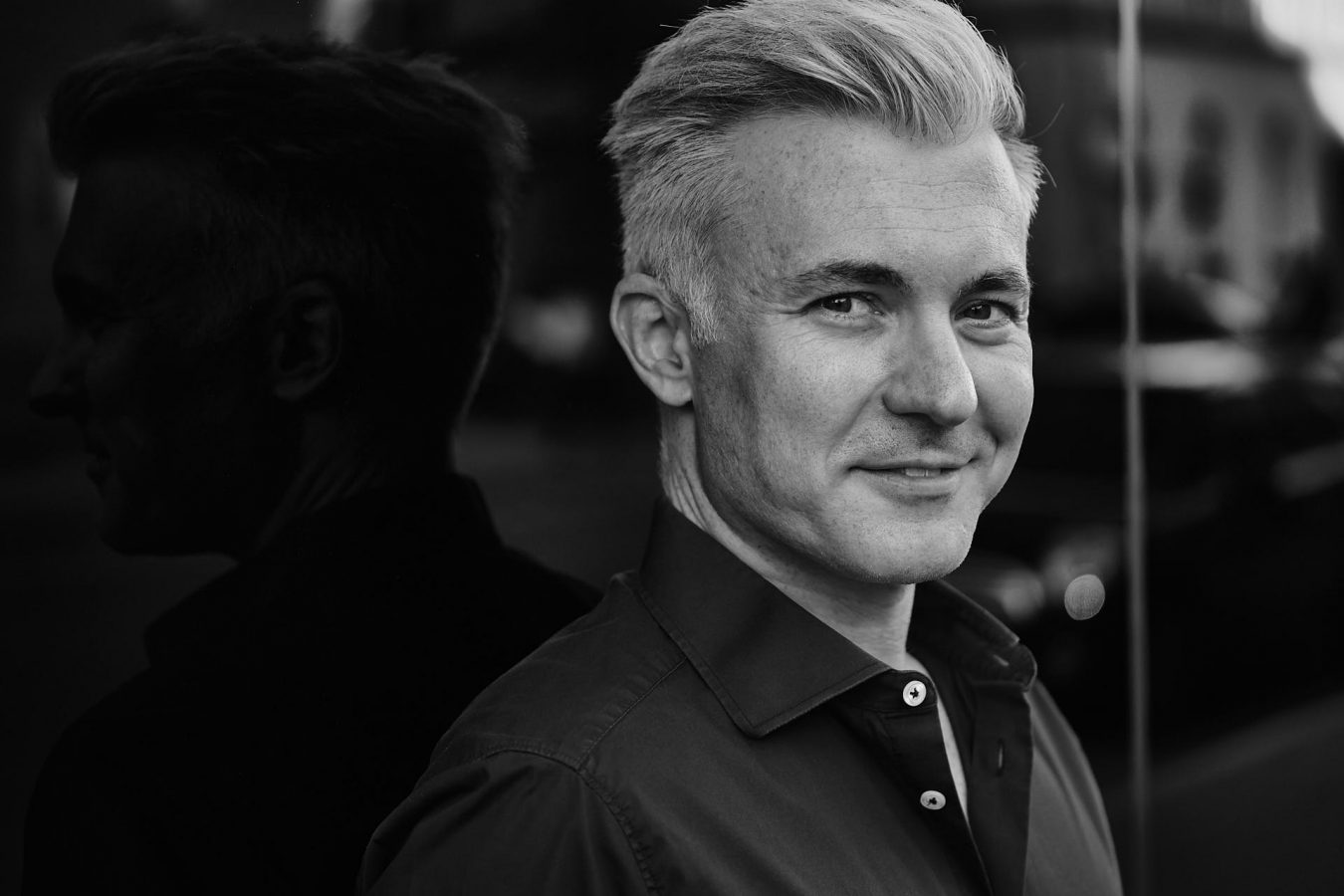 Portrait München Mann mit Glasspiegelung schwarzweiß